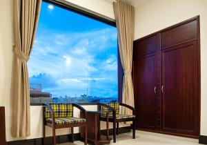 a room with a table and chairs and a large window at MINH LÂM HOTEL in Pleiku