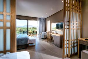 a bedroom with a bed and a living room with a view at Stella Palace Aqua Park Resort in Hersonissos