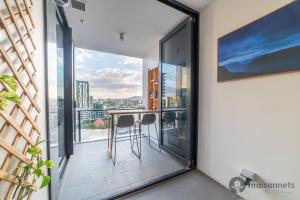 Un balcón con una mesa y vista a la ciudad. en Mod Brisbane Apt near Southbank W Pool & Parking, en Brisbane