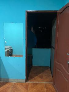 an open door to a room with a blue wall at Casa Hogar Martita in Puerto Baquerizo Moreno