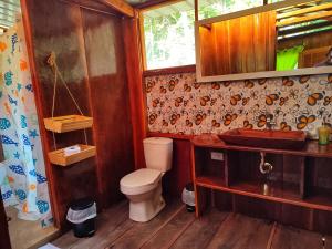 a bathroom with a toilet and a sink at Mama Yeya raíces in San Cipriano