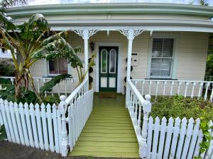 une terrasse couverte blanche avec une clôture blanche sur une maison dans l'établissement Quiet secret garden Sun-trap, à Auckland