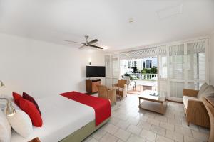 a bedroom with a bed and a living room at Ramada By Wyndham Cairns City Centre in Cairns