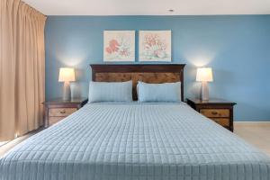 a blue bedroom with a large bed with two lamps at Caribbean Oasis on Sunset Beach in Maho Reef