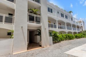 a large white building with palm trees in the courtyard at Maho Beach House - Spacious 1 Bedroom Suite in Maho Reef
