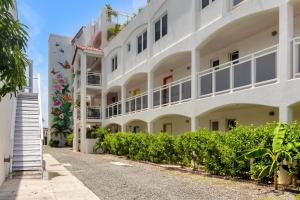 a large white building with bushes in front of it at Maho Beach House - Spacious 1 Bedroom Suite in Maho Reef +9 photos