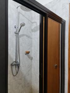 a shower in a bathroom with a glass door at MoRue's Den in Mabini