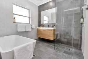 努里乌特帕Mid Century 4 Bedroom Getaway in Barossa Vineyard的带浴缸、水槽和淋浴的浴室