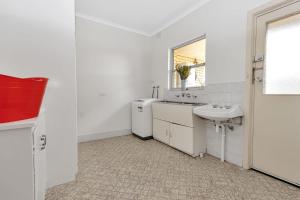a white bathroom with a sink and a mirror at Mid Century 4 Bedroom Getaway in Barossa Vineyard in Nuriootpa +34 photos
