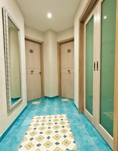 a hallway with blue tile flooring and glass doors at B&B Shining in Avola