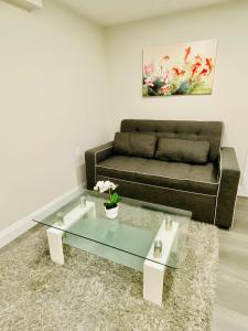 uma sala de estar com um sofá e uma mesa de café em vidro em VJ Home em Toronto