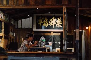 una mujer sentada en un mostrador en un restaurante en Funzpace, en Hengchun