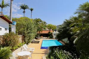 a villa with a swimming pool and palm trees at Casa de Novela in Pirenópolis