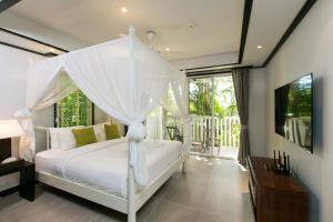 1 dormitorio con 1 cama blanca con dosel en Katamanda Villa Mila A1, en Kata Beach