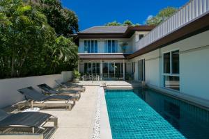 卡塔海灘的住宿－Katamanda Villa Mila A1，一座房子旁带躺椅的游泳池