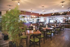 un restaurante con mesas de madera y sillas verdes en Carriers Arms Hotel Motel en Maryborough