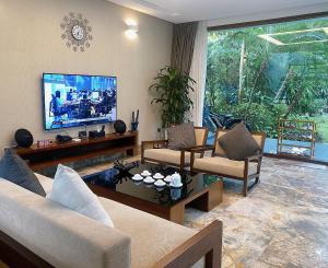 sala de estar con sofá y TV en Suha Villa- Flamingo Dai Lai Resort, en Phúc Yên