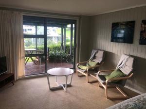 a living room with two chairs and a table at The Pacific Room, Tapeka Point in Russell