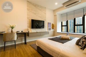 Ceylonz Suite KLCC, Travelet في كوالالمبور: غرفة نوم بسرير ومكتب وتلفزيون