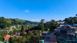 a view of a city with a mountain in the background at Tigerhill Homestay in Darjeeling