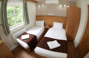 a small room with two beds and a window at Kensington Suite Hotel in London