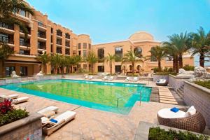 a swimming pool with lounge chairs and a resort at Sheraton Qingyuan Lion Lake Resort in Qingyuan