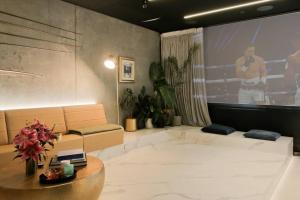 una sala de estar con una gran pantalla de proyección y un sofá en Entertainers penthouse with 5 bedrooms pool & spa en Auckland