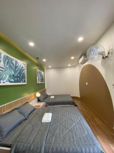 2 camas en una habitación con paredes verdes en Happy Hotel Bình Tân, en Ho Chi Minh