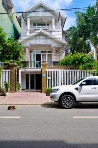 une voiture blanche garée devant une maison dans l'établissement Tuyet Suong Villa Hotel, à Quảng Ngãi