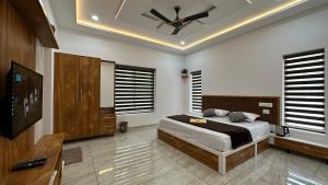 a bedroom with a bed and a ceiling fan at Rhythm Holiday Home in Sultan Bathery