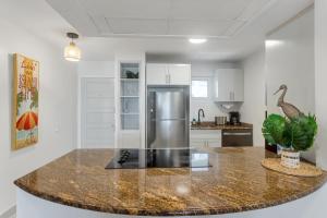 a kitchen with a granite counter top and a refrigerator at Lux Maho Reef 1BR Suite Condo next to The Morgan Resort in Maho Reef