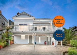 een huis met een balkon en een bord ervoor bij Grand villa plus studio in central location in Auckland