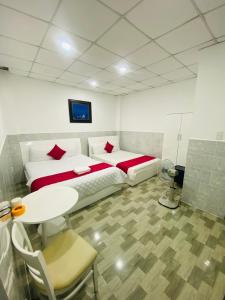 a bedroom with a bed and a table and a table and chairs at Vĩnh Ph&uacute; Gia Hotel in Ho Chi Minh City