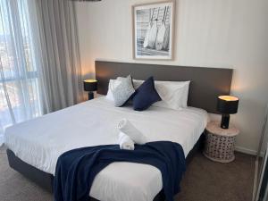 a bedroom with a large bed with blue and white pillows at Incredible ocean views 3 Bed 18th floor in Gold Coast +20 photos