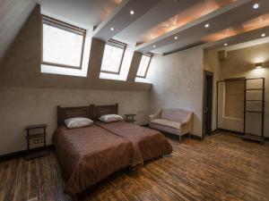 a bedroom with a bed and a chair and windows at Basmanka Convent Hotel in Moscow