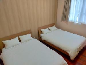 宫古岛Horinoyado的房间里有两张并排的床