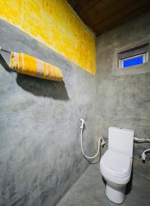 bagno con servizi igienici e asciugamano. di Grand Cabin Pinnawala a Rambukkana