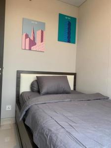 a bed in a bedroom with two pictures on the wall at Batam Two Bedrooms Apartment - One Residence 25AJ in Batam Center