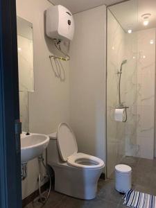 a bathroom with a toilet and a sink and a shower at Batam Two Bedrooms Apartment - One Residence 25AJ in Batam Center