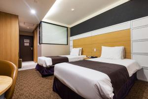 Postel nebo postele na pokoji v ubytování Eastern Hotel Jeju