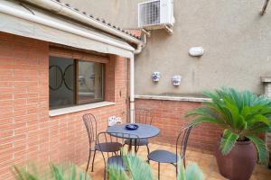 a patio with a table and chairs next to a brick wall at Stay U-nique House Torre Damians in Barcelona
