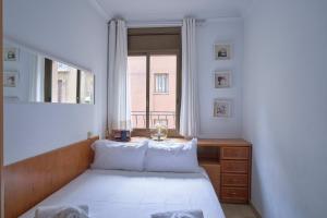 una piccola camera con letto e finestra di Stay U-nique House Torre Damians a Barcellona