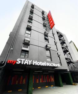 a hotel building with a sign that reads stay hotel beijing at mySTAY Hotel BGC North in Manila