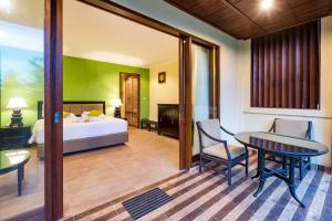 ein Schlafzimmer mit einem Bett und einem Tisch und Stühlen in der Unterkunft Umasari Rice Terrace Villa by AGATA in Tabanan + 37 Fotos