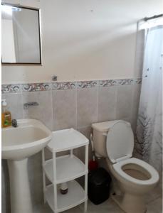La salle de bains est pourvue de toilettes blanches et d'un lavabo. dans l'établissement El Rincón perfecto 2, 