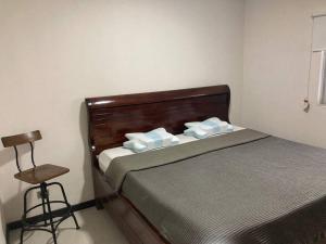 ein kleines Schlafzimmer mit einem Bett und einem Stuhl in der Unterkunft Hermoso Apartamento en Alajuela in Alajuela