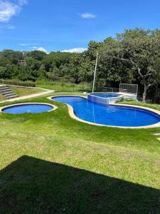 eine Aussicht auf einen Pool im Gras in der Unterkunft Hermoso Apartamento en Alajuela in Alajuela