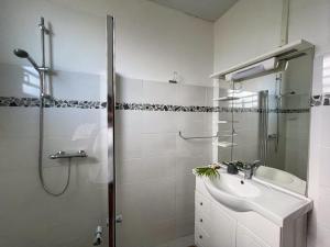 ein weißes Bad mit einem Waschbecken und einer Dusche in der Unterkunft Casa Tropical · T3 Calme & Spacieux in Le Lamentin