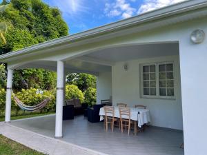 eine überdachte Terrasse mit einem Tisch und Stühlen in der Unterkunft Casa Tropical · T3 Calme & Spacieux in Le Lamentin