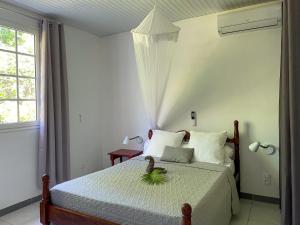 ein Schlafzimmer mit einem Bett mit einer Pflanze darauf in der Unterkunft Casa Tropical · T3 Calme & Spacieux in Le Lamentin